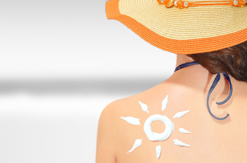 Soleil peint en crème solaire sur le dos d'une femme